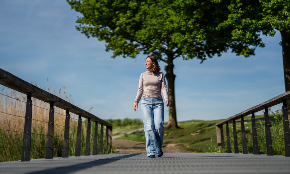 Vrouw die over een brug heen loopt 