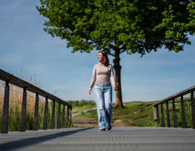 Vrouw die over een brug heen loopt 